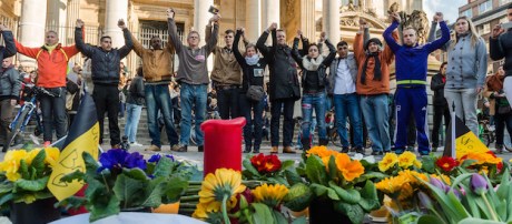 People hold hands in solidarity near a memorial to attack victims outside the stock exchange in Brussels on Tuesday, March 22, 2016. Explosions, at least one likely caused by a suicide bomber, rocked the Brussels airport and subway system Tuesday, prompting a lockdown of the Belgian capital and heightened security across Europe. (AP Photo/Geert Vanden Wijngaert)